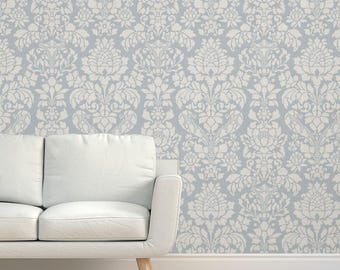 May include: A white damask pattern wallpaper with a light blue background. The wallpaper is shown on a wall behind a white sofa.