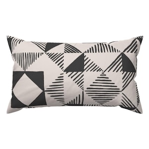 May include: A black and white geometric patterned throw pillow with a rectangular shape.