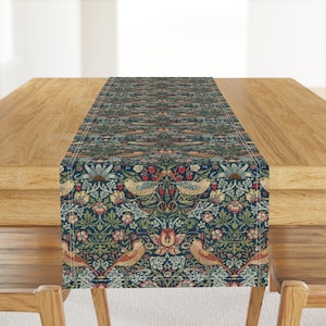 Puede incluir: Un camino de mesa azul y verde con un patrón repetitivo de pájaros, flores y hojas. El patrón está inspirado en el movimiento Arts and Crafts.