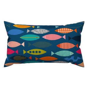 May include: A blue pillow with a pattern of colorful fish. The fish are all different shapes and sizes and have various patterns, including polka dots, stripes, and geometric designs.