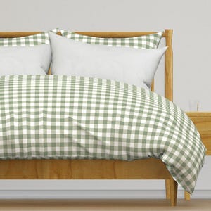 Peut inclure: Une housse de couette en vichy vert et blanc sur un cadre de lit en bois. La housse de couette a un motif à carreaux.