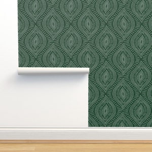 Puede incluir: Un rollo de papel tapiz verde con un patrón blanco repetitivo de formas de lágrima estilizadas. El papel tapiz está parcialmente desenrollado, revelando el fondo verde.