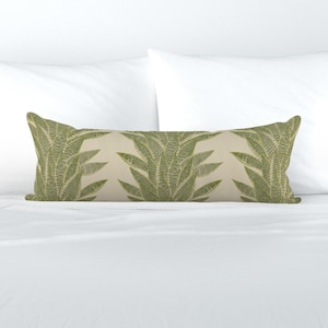 May include: A long, rectangular throw pillow with a cream-colored background and a repeating pattern of green leafy plants.