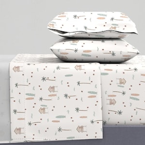 May include: White bedding set with a tropical print featuring palm trees, surfboards, and small houses. The set includes a fitted sheet, flat sheet, and two pillowcases.