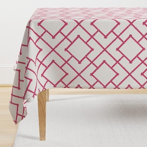 May include: A white tablecloth with a pink geometric pattern. The pattern is a repeating diamond shape with a bamboo-like design.
