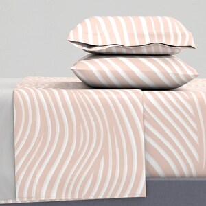 May include: A pink and white striped bedding set with a wavy pattern. The set includes a fitted sheet, flat sheet, and two pillowcases.