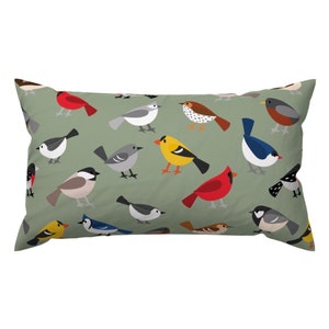 May include: A green pillow with a repeating pattern of colorful birds. The birds are in various poses and colors, including red, yellow, blue, and gray.