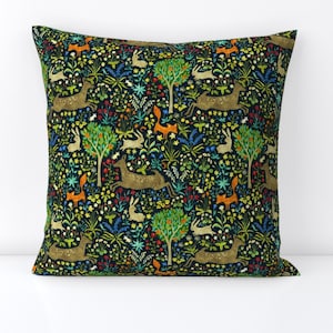 May include: A dark green throw pillow with a repeating pattern of deer, foxes, and rabbits in a forest setting. The pattern is colorful and includes shades of orange, yellow, blue, and green.