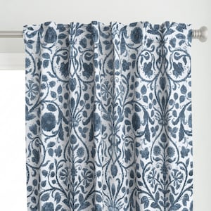 May include: Blue and white patterned curtain panels with a floral design. The pattern is a repeating design of stylized flowers and leaves.