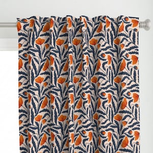 May include: A curtain panel featuring a repeating botanical pattern of vibrant orange poppy flowers and dark navy blue foliage set against a light cream background. The fabric hangs from a silver metal rod, displaying vertical folds and pleats.