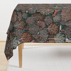 May include: A dark green tablecloth with a woodland pattern featuring trees, animals, and birds. The pattern is in shades of brown, orange, and green.