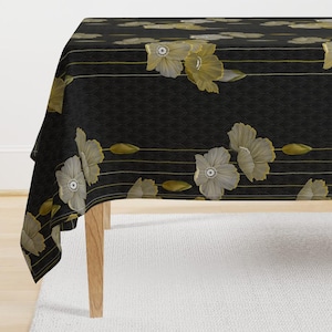 Può includere: Una tovaglia nera con un motivo floreale. Il design presenta grandi fiori stilizzati nei toni del crema e dell'oro, su uno sfondo scuro con un sottile motivo strutturato. Linee orizzontali dorate e accenti di foglie completano il design.