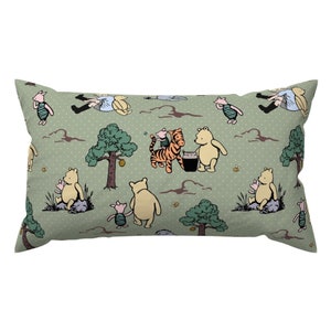 May include: A green pillow with a repeating pattern of Winnie the Pooh and his friends, including Piglet, Tigger, and Eeyore. The characters are depicted in a cartoon style and are surrounded by green trees and honey pots.