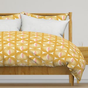 May include: A yellow and pink patterned duvet cover with a white background. The duvet cover is on a wooden bed frame with two white pillows.