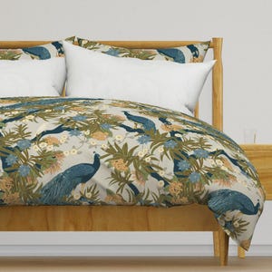 May include: A beige duvet cover with a repeating pattern of peacocks and tropical plants in shades of blue, green, and gold.