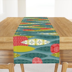 May include: A teal, green, yellow, and red geometric patterned table runner with a wavy design. The runner features circles with floral patterns and abstract shapes.