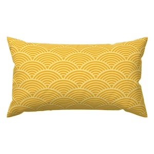 Può includere: Un cuscino giallo con un motivo geometrico di semicerchi sovrapposti.