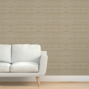 Può includere: Un divano bianco con una parete di sfondo di colore marrone chiaro e texture.