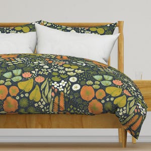 May include: A navy blue duvet cover with a floral pattern featuring orange, yellow, and green flowers and leaves. The duvet cover is on a wooden bed frame.