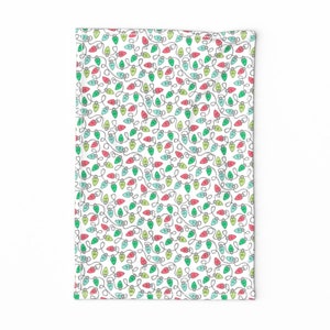 May include: White fabric with a repeating pattern of green, red, and blue light bulbs. The light bulbs are connected by gray lines, creating a string of lights pattern.