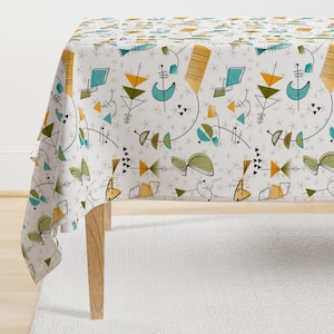 May include: A white tablecloth with a mid-century modern geometric pattern in shades of teal, yellow, and green. The pattern features abstract shapes, lines, and stars.