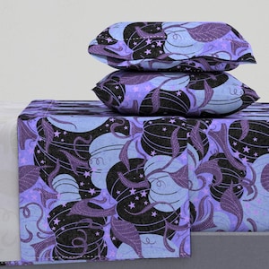 May include: A purple and blue bedding set with a whimsical pattern of stylized gourds and stars. The set includes a flat sheet, fitted sheet, and two pillowcases.