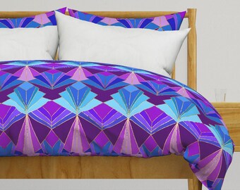 May include: A purple, blue, and gold geometric patterned duvet cover with a white pillow on a wooden bed frame.