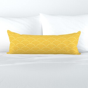 May include: A yellow lumbar pillow with a geometric pattern of overlapping half circles.