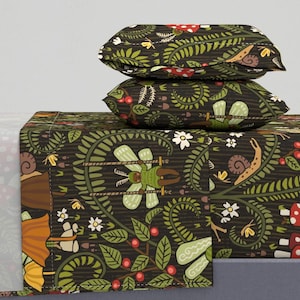 Puede incluir: Un juego de cama verde oscuro con un patrón de bosque caprichoso. El patrón presenta hojas verdes, bayas rojas, hongos, caracoles y un insecto verde en un columpio. El juego incluye una sábana plana, una sábana ajustable y dos fundas de almohada.