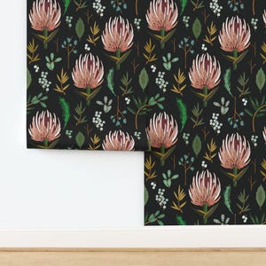 May include: Wallpaper featuring a repeating pattern of pink protea flowers, green leaves, and small white berries on a solid black background. The design includes various botanical elements like thin brown stems and fern-like foliage.