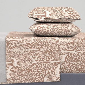 Può includere: Set di biancheria da letto con un motivo a bosco marrone e bianco. Il design presenta alberi, uccelli e cervi. Il set comprende due cuscini e un lenzuolo piegato, tutti con lo stesso design ispirato alla natura.