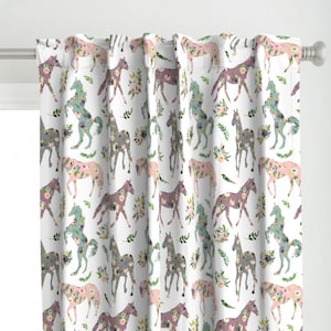 Puede incluir: Cortinas blancas con un patrón repetido de caballos florales en tonos de rosa, gris y azul. Los caballos están silueteados sobre un fondo blanco.