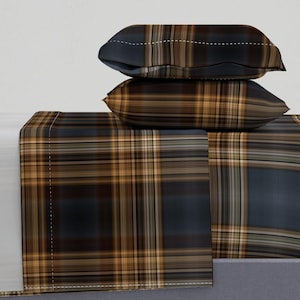 May include: A set of plaid bedding in shades of brown, tan, and blue. The set includes a flat sheet, fitted sheet, and two pillowcases.