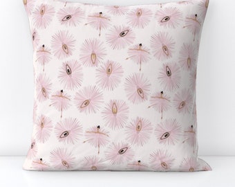 May include: A white throw pillow with a pink and white pattern of ballerinas in tutus. The ballerinas are in a variety of poses, and the tutus are all different shapes and sizes.