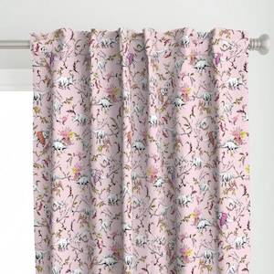 May include: Pale pink curtain panel with a repeating pattern of white dinosaurs, pink and yellow flowers, and brown vines. The dinosaurs are illustrated. The curtain is hanging on a silver curtain rod.