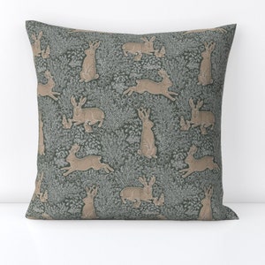 May include: A green throw pillow with a repeating pattern of brown rabbits and a floral design.