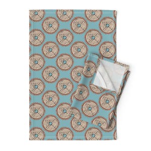May include: A blue kitchen towel with a repeating pattern of beige and brown circles. The circles have a woven texture and a red outline.