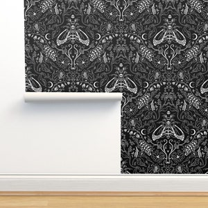 May include: Black and white wallpaper with a repeating pattern of moths, flowers, and crescent moons. The design is intricate and detailed, creating a gothic and whimsical aesthetic.