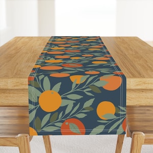May include: A navy blue table runner with a repeating pattern of orange fruit and green leaves.