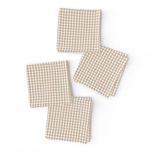 Könnte beinhalten: Vier braune und weiße Gingham-Servietten. Die Servietten sind gefaltet und in quadratischer Form angeordnet.