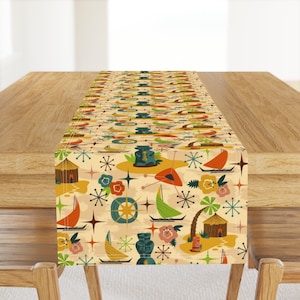 May include: A beige table runner with a repeating pattern of tiki idols, palm trees, boats, and stars. The pattern is in shades of green, blue, orange, red, and yellow.