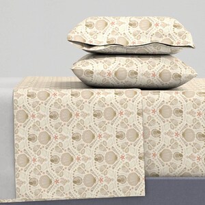 Puede incluir: Un juego de cama beige y marrón con un patrón de conchas marinas y estrellas de mar. El juego incluye una sábana bajera, una sábana plana y dos fundas de almohada.