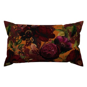 May include: A rectangular pillow with a floral pattern. The pillow features a dark red, burgundy, and purple floral design on a mustard yellow background.
