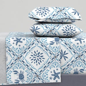May include: A white and blue patterned bedding set with a geometric design featuring sea creatures like starfish and crabs. The set includes a fitted sheet, flat sheet, and two pillowcases.