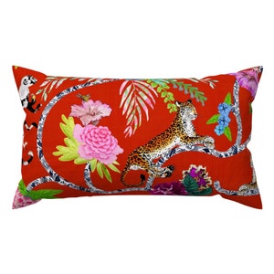 May include: Red rectangular pillow with a colorful design featuring a leopard, flowers, and leaves.