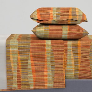 May include: A set of orange, brown and green striped bedding with two matching pillowcases. The bedding has a woven texture.