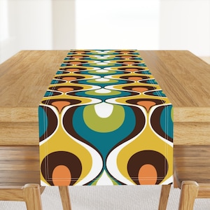 May include: A yellow, brown, orange, green, and blue geometric table runner with a repeating pattern of circles and curves.