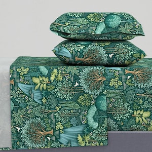 Könnte beinhalten: Ein Bettwäsche-Set in Grün und Gold mit einem Wald-Druck, der Bäume, Blätter und Vögel zeigt. Das Set beinhaltet ein flaches Laken, ein Spannbettlaken und zwei Kissenbezüge.