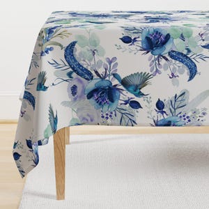 May include: A white tablecloth with a blue and purple floral pattern. The pattern features watercolor-style flowers, leaves, and birds.
