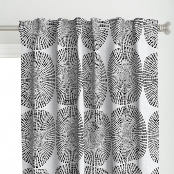 May include: White curtain panel with a repeating pattern of large, black, oval shapes. Each oval features a central spiral design with radiating lines, creating a textured, abstract look. The curtain is hanging on a silver rod.